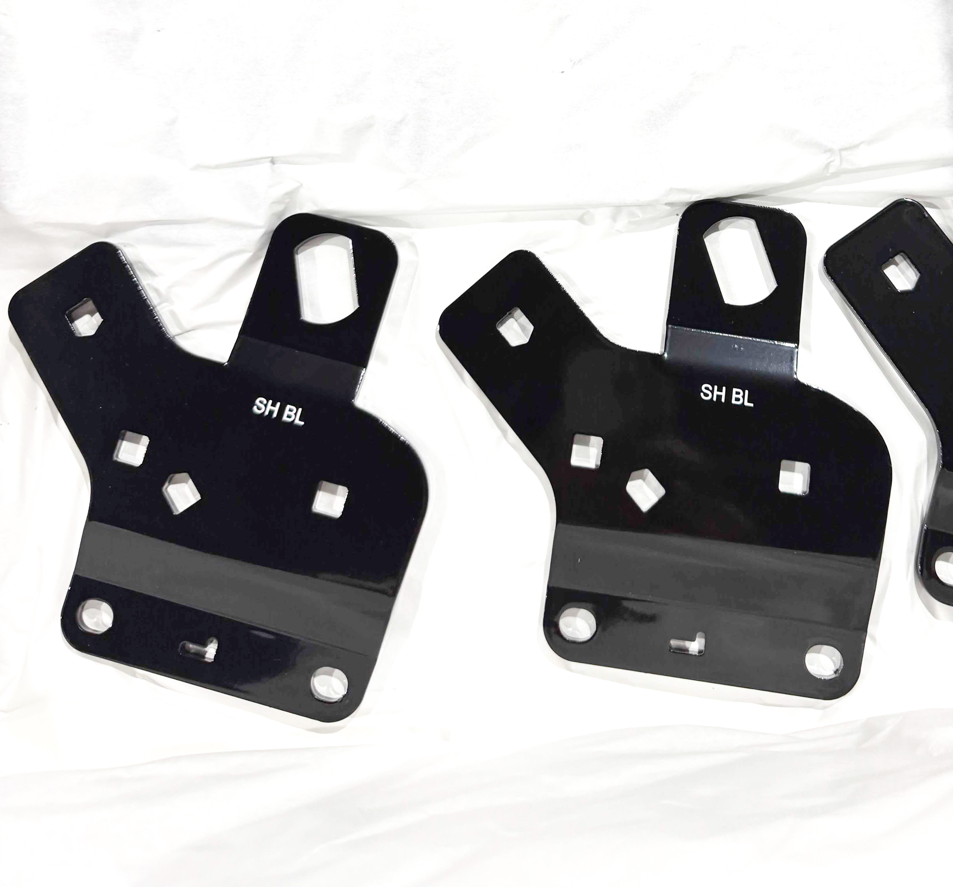 Black mounting plates with raised tabs, angular openings, and bent edges.
